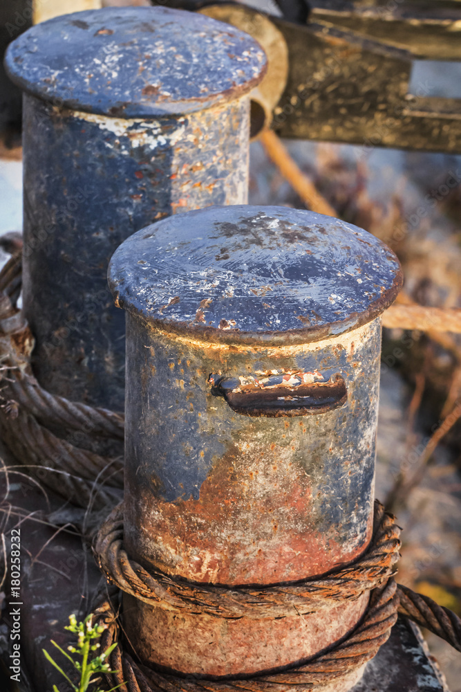 Old Battered Rusty Iron Bollards With Coiled Corroded Steel Cable