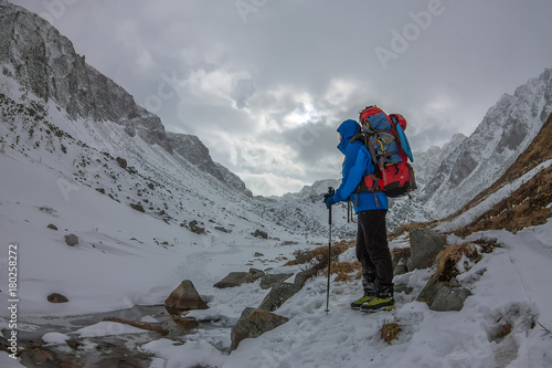 Female mountaineer with backpack, helmet and harness with climbing in mountain
