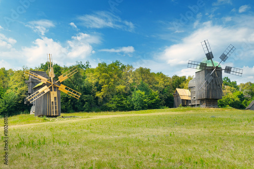 old wooden windmills in a field