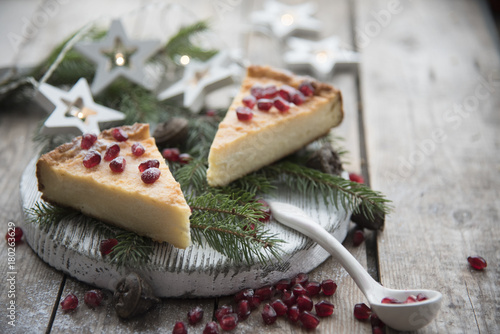 Cheesecake with pomegranate seeds, Christmas tree branches and Christmas decorations