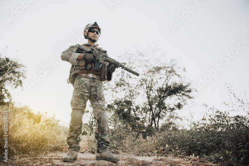 Closeup asian soldier with weapons in hand at the forest,prepare for maneuver,military veterans concept
