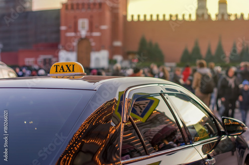 taxi to the center of the city on a busy street with many people and reflected in the glass evening lights of metropolis Moscow