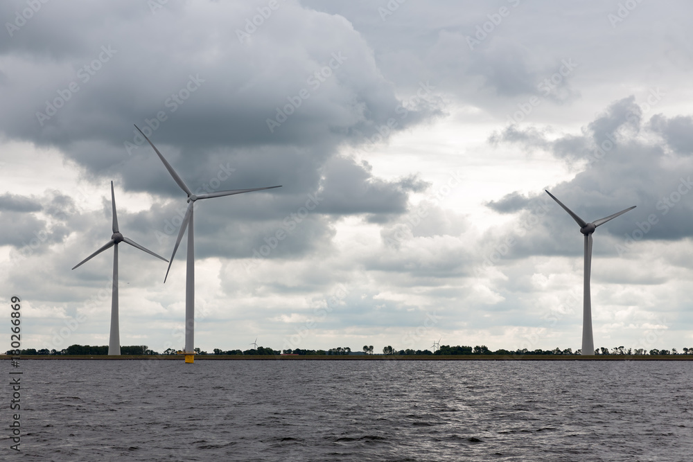 Large offshore windfarm near Dutch coast with cloudy sky. This park in the lake IJssselmeer near Urk is the biggest windfarm of the Netherlands