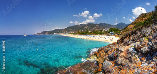 Fototapeta Naklejka Na Ścianę i Meble -  Paradise tropical lagoon with rocky beach in Alanya, Turkey. Sea and mountains landscape in sunny summer day. Alanya beach panoramic view. Tropic bay with rocks on coastline.
