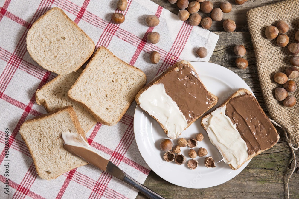 top view of bread slice with chocolate and vanilla nutella cream on wooden table top view of bread slice with chocolate and vanilla nutella cream on wooden table