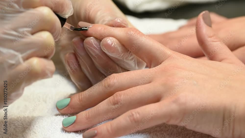 Manicure master applies cuticle oil for nails Manicure master applies cuticle oil for nails