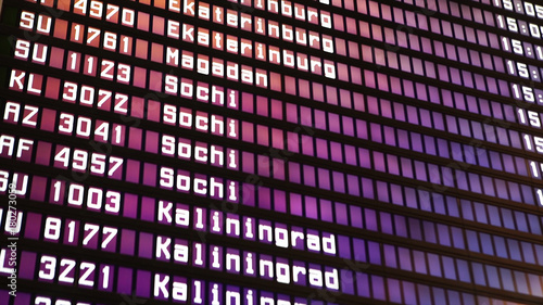 Departures board at the airport. Flight information electronically timetable. Split flap mechanical departures board. Flight schedule. Scoreboard flights photo