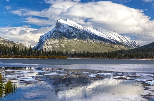 Distant Snowy Mountain Rundle Landscape reflected in calm water of Vermilion Lakes in Banff National Park after early Autumn Snowfall in Canadian Rocky Mountains