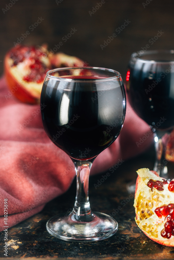 Fresh pomegranate juice in glass over black background. Fresh pomegranate juice in glass over black background.