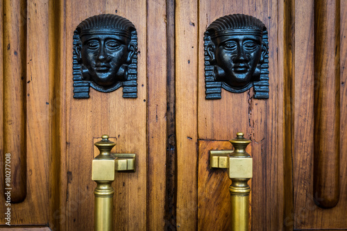 Sphinx heads entrance on wooden door photo