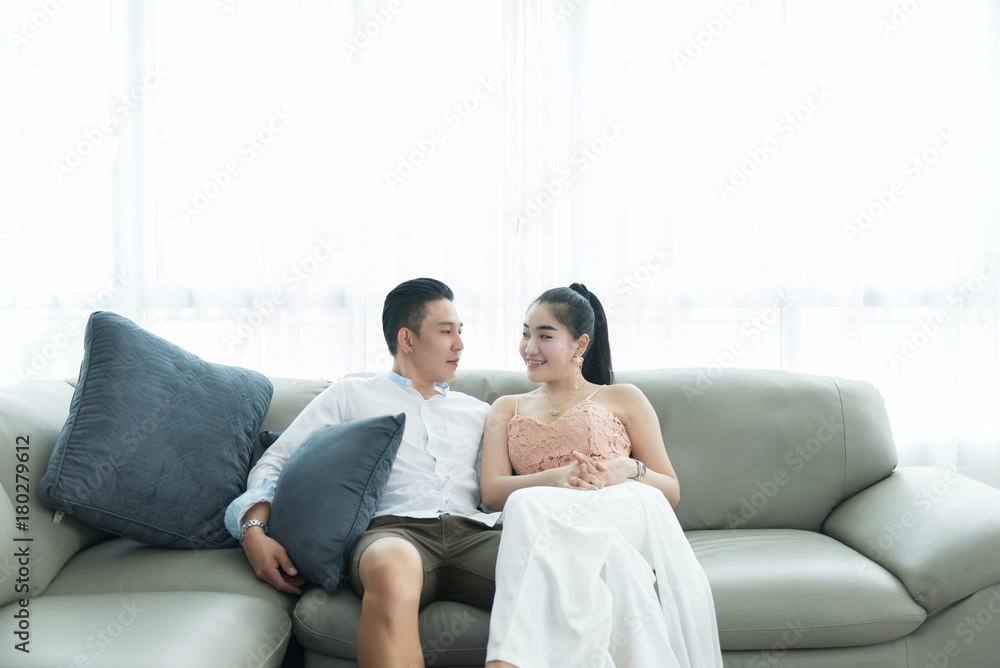 Asian couple on sofa looking eyes together in the livingroom Asian couple on sofa looking eyes together in the livingroom