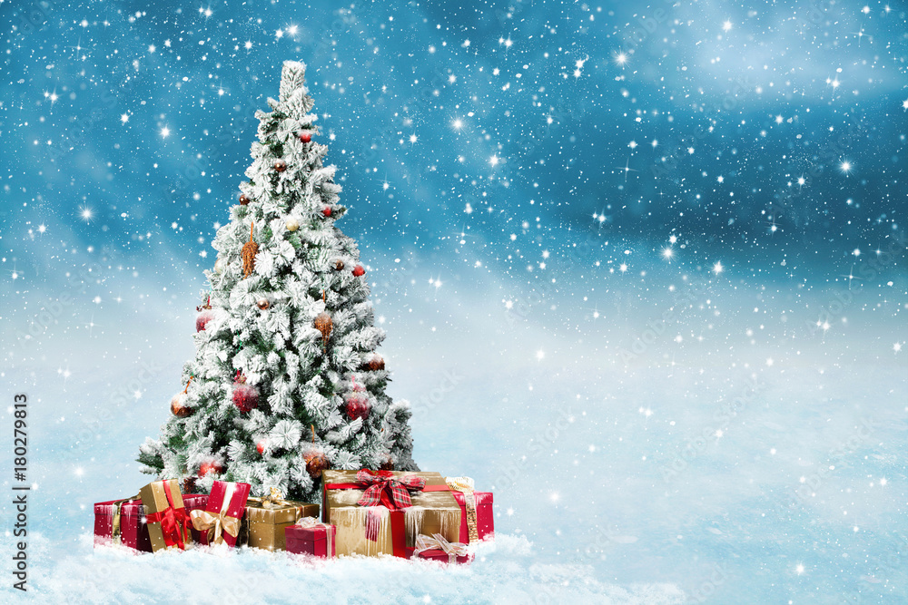 verschneiter und geschmückter Weihnachtsbaum im Schneetreiben mit vielen Geschenkpäckchen
