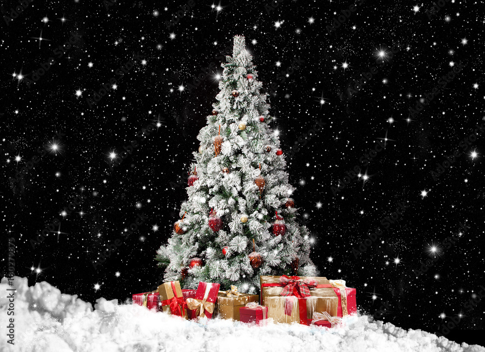 festlich geschmückter Christbaum im Schnee mit vielen Geschenkpaketen