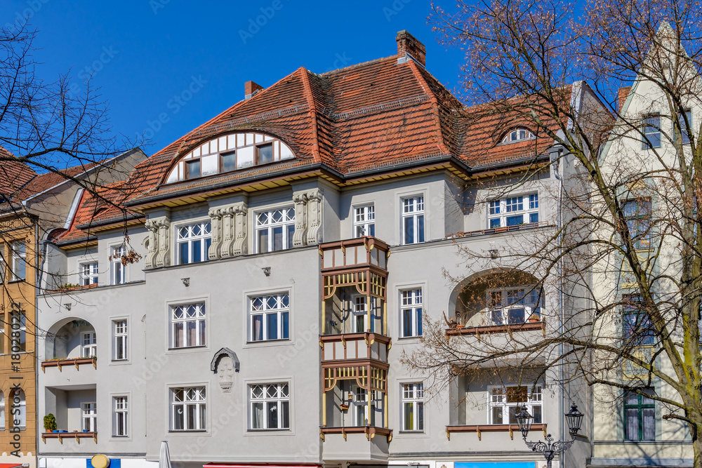 Denkmalgeschütztes Wohn- und Geschäftshaus mit hölzernen Balkonelementen in Berlin-Alt-Tegel