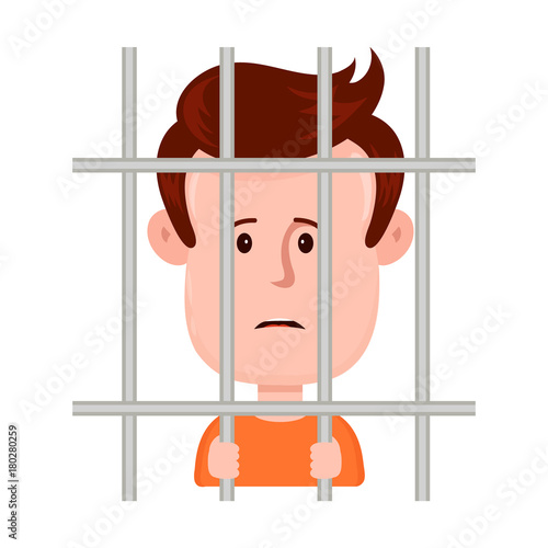 Young sad man prisoner behind bars, 