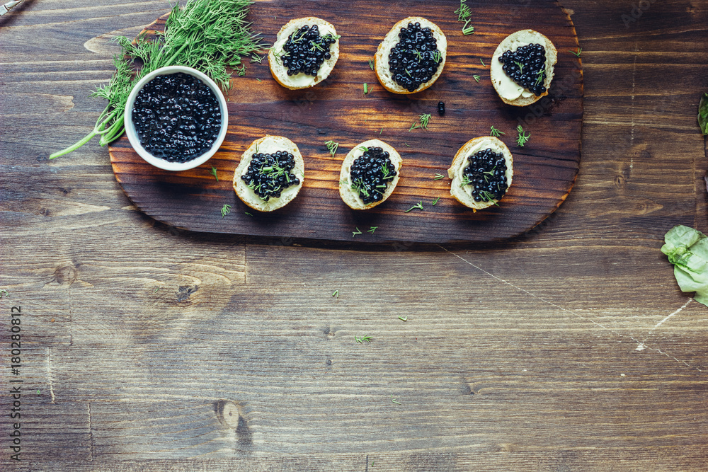Top view of black caviar appetizers at wooden board. Top view of black caviar appetizers at wooden board.