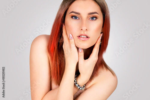 Fashion portrait of a beautiful young woman with tinted red hair