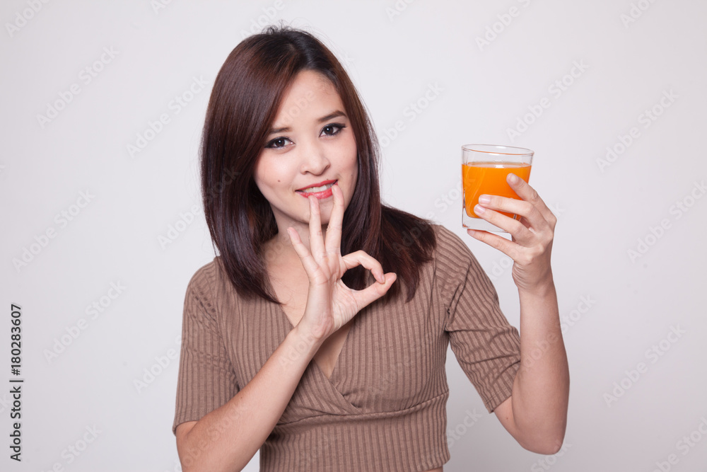 Young Asian woman show OK drink orange juice.
