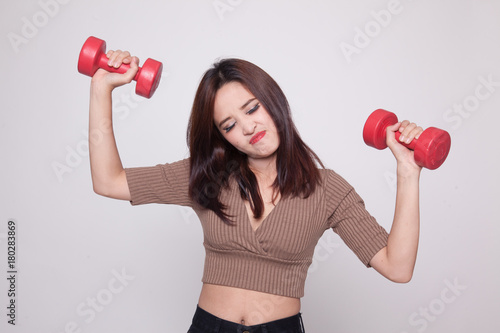 Exhausted Asian woman with dumbbells.