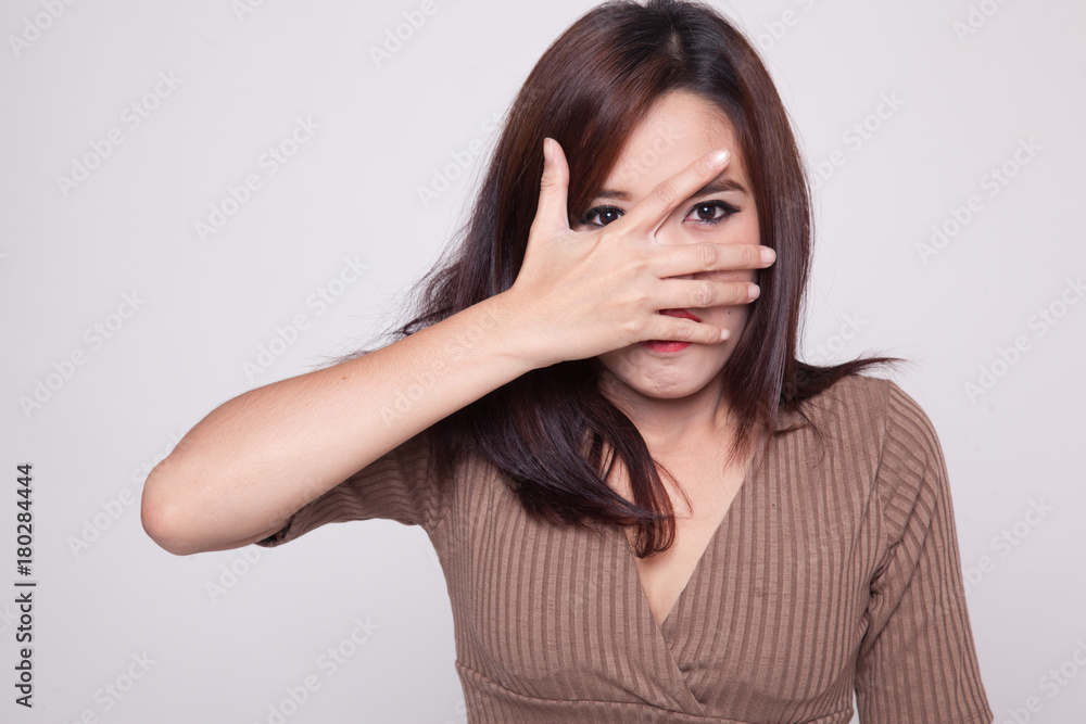 Beautiful young Asian woman peeking through fingers. Beautiful young Asian woman peeking through fingers.