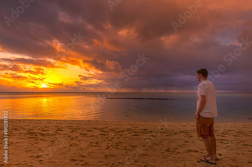 Blick auf den Sonnenuntergang am Meer mit einem Mann