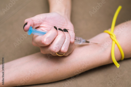 Ótimo conceito de drogas recreativas, mulher injetando drogas no braço.