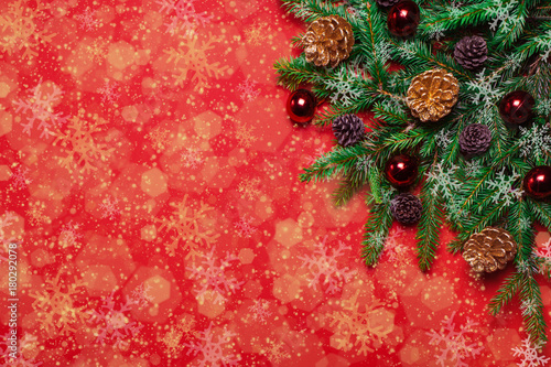 Red Christmas New Year's background with fir branches, fir cones, lights and snowflakes. Christmas wallpaper. Christmas, New Year's composition with copy space for text. Flat lay, top view