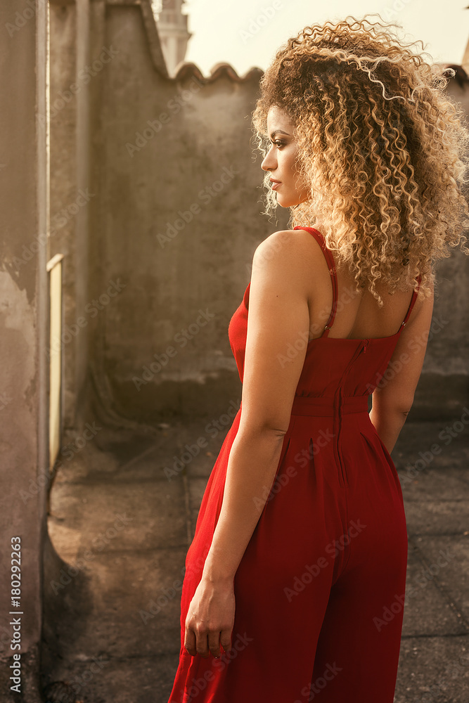 Beautiful and elegant woman back portrait standing on rooftop and looking aside