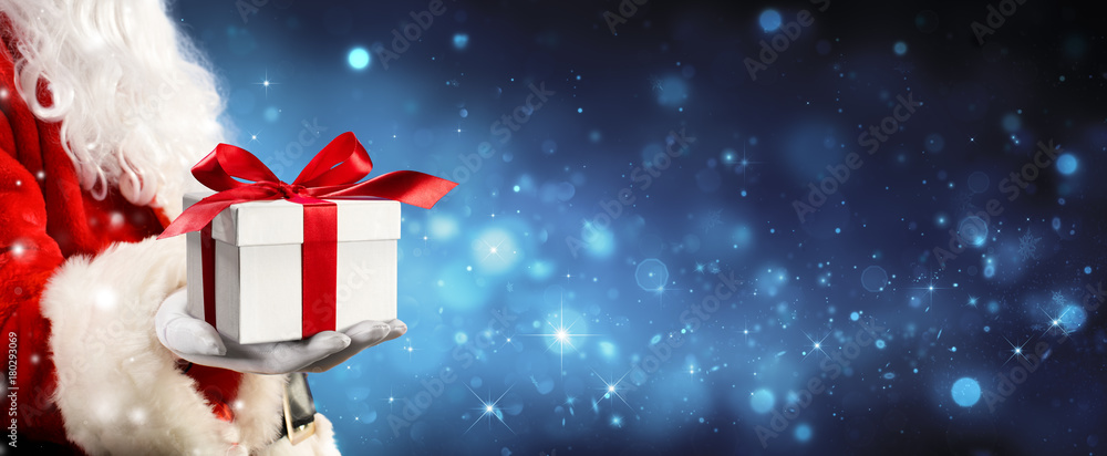 Santa Claus Giving A Giftbox In Magic Night
 - obrazy, fototapety, plakaty 