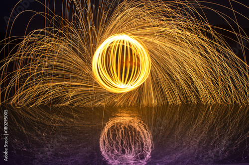Light painting / light drawing with fire and steel wool on the lake