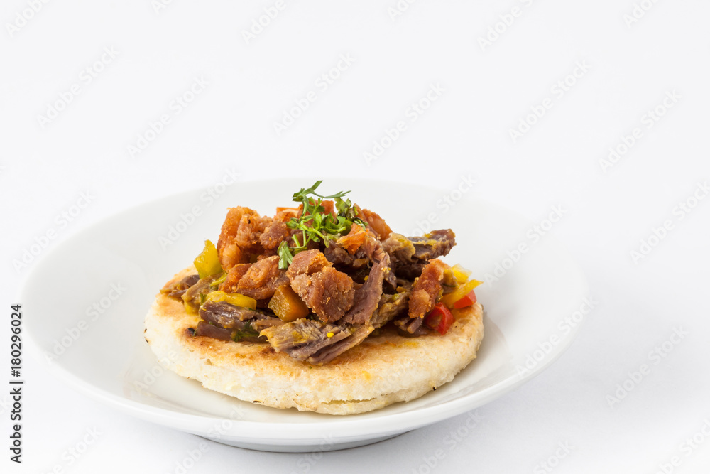 Colombian arepa topped with shredded beef and pork rind Colombian arepa topped with shredded beef and pork rind