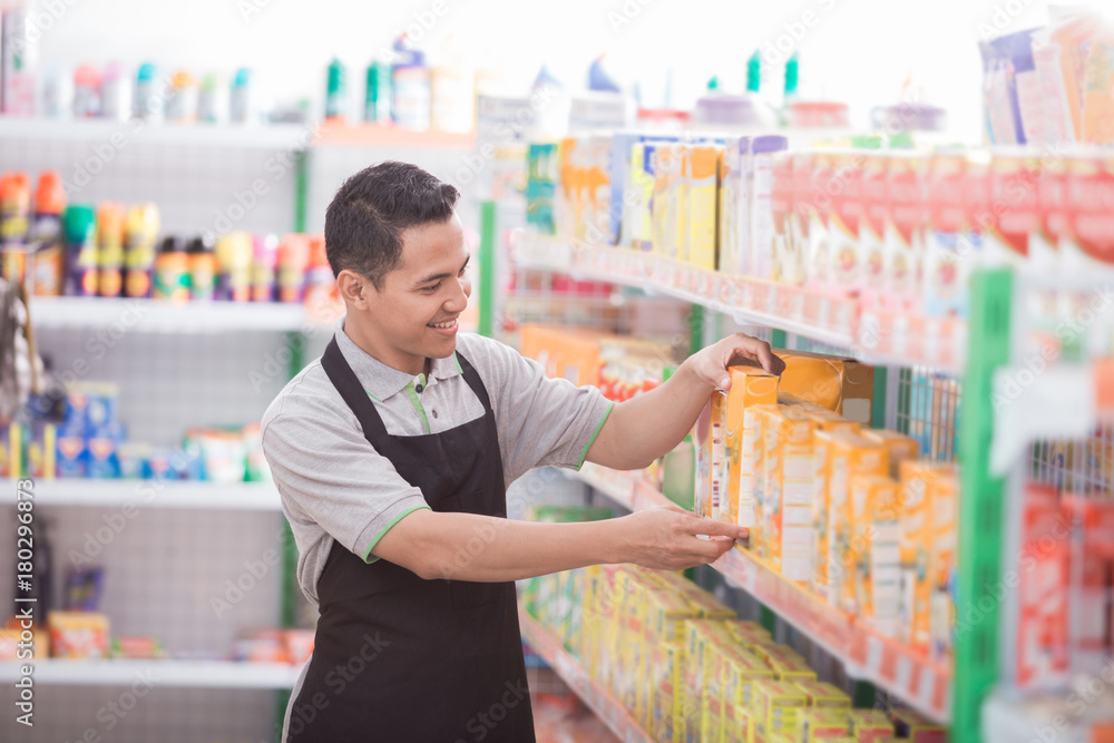 male shopkeeper working in a grocery store male shopkeeper working in a grocery store