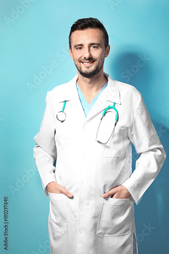 Male doctor on color backgr...