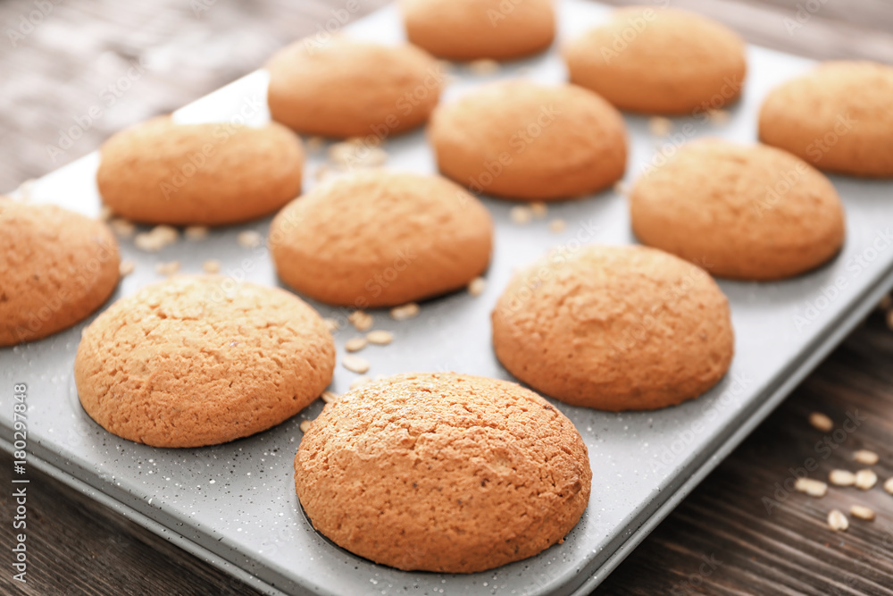 Baking tray with delicious oatmeal cookies on table, closeup Baking tray with delicious oatmeal cookies on table, closeup