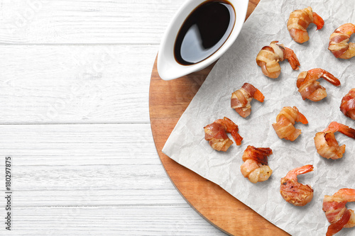 Board with shrimps wrapped in bacon on table © Africa Studio