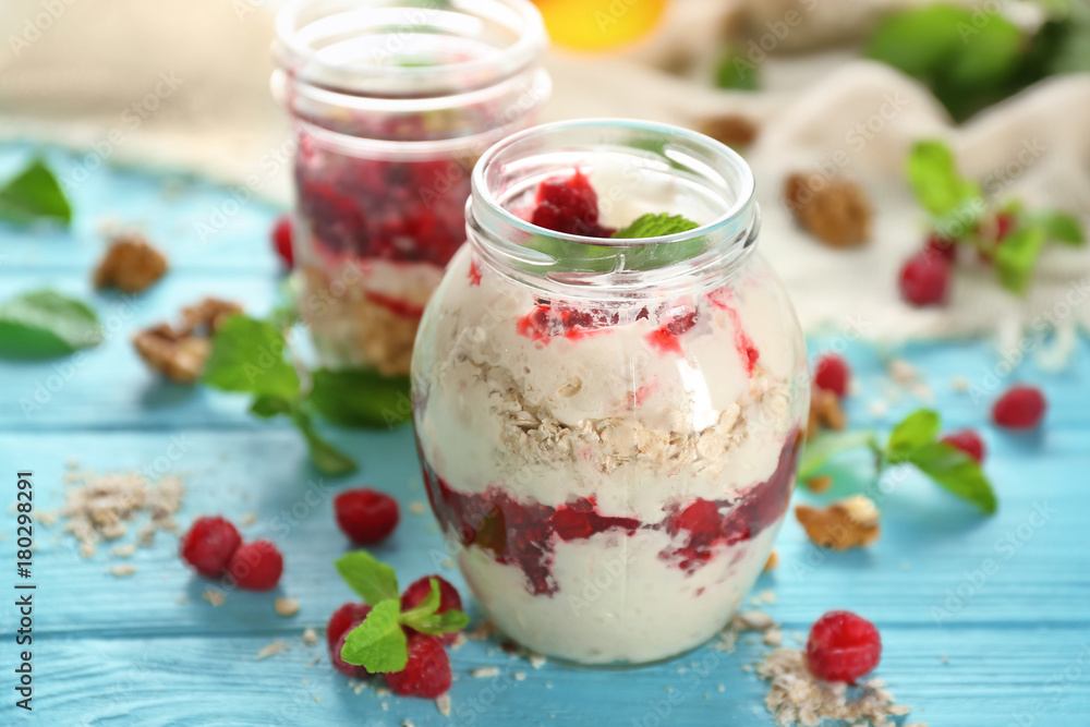 Delicious parfait with raspberry and oatmeal in glass jar on table Delicious parfait with raspberry and oatmeal in glass jar on table