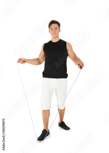 Sporty young man with jumping rope on white background