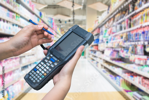 Asian hands holder handheld with supermarket background,check stock,worker use for keep data of products,Connect database online with wifi