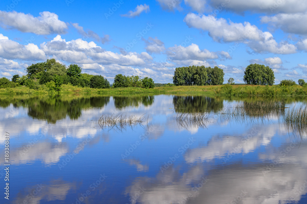 Fototapeta premium River and clouds above it on a summer day