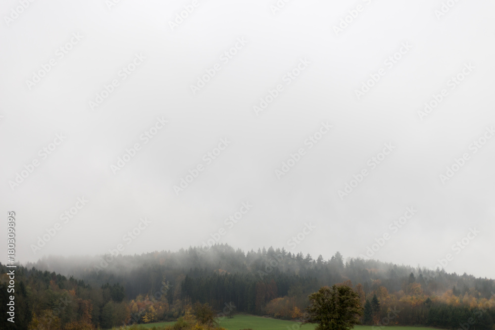landscape with visible horizon on a foggy november day with indian fall colors