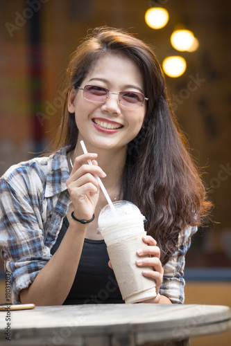 toothy smiling face happiness emotion of younger asian woman with cool drink bottle in hand