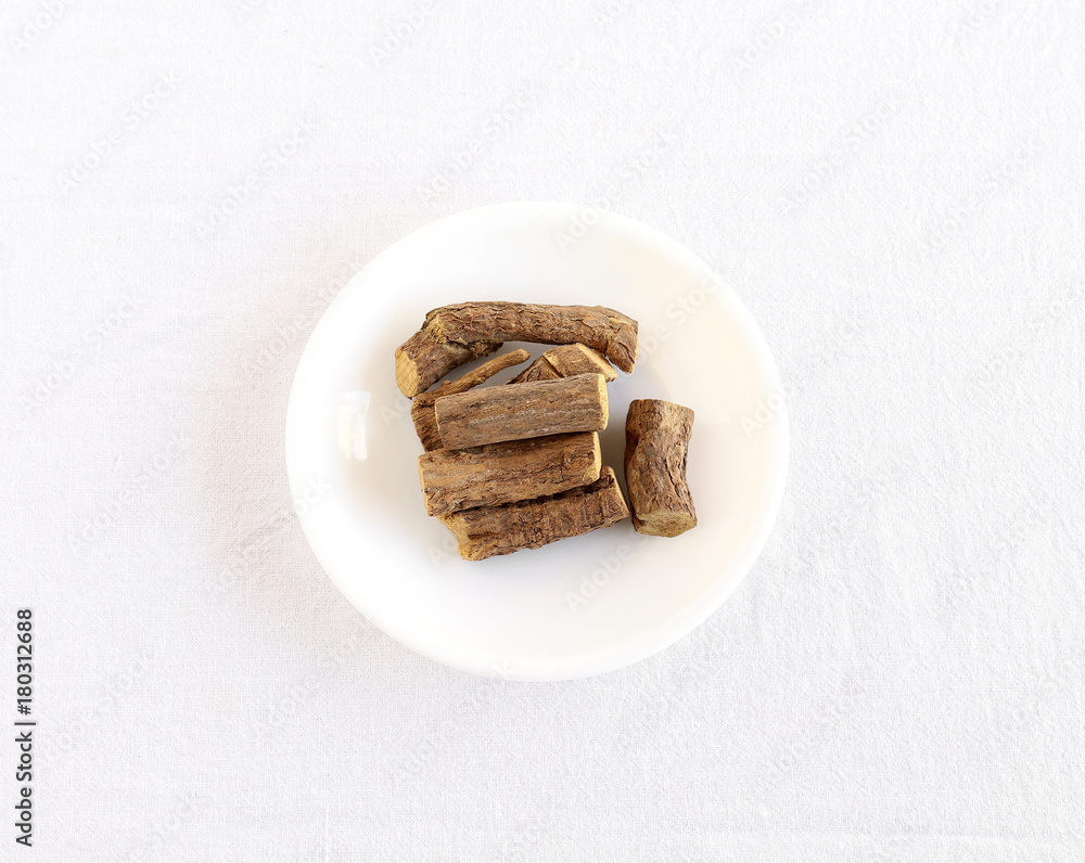 Licorice roots or sweet roots, a sweetener and a potential natural medicine, on a plate. Licorice roots or sweet roots, a sweetener and a potential natural medicine, on a plate.