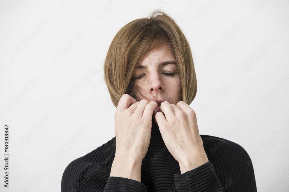 sad attractive woman is pulling up pullover collar. Lifestyle concept. Isolated studio shot. sad attractive woman is pulling up pullover collar. Lifestyle concept. Isolated studio shot.
