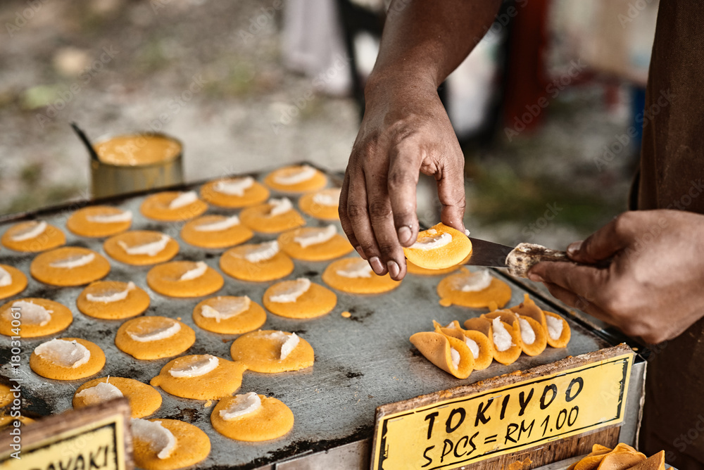 Cooking of Tokiyoo, traditional asian sweet pancakes with coconut filling inside. Classic asian street food from Langkawi island in Malaysia. Close up.