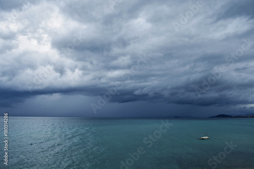 Dark sky at stormy weather with huge heavy clouds over the sea