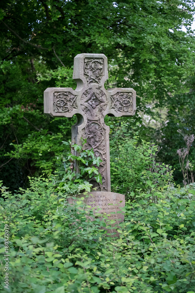 Overgrown cross gravestone Overgrown cross gravestone