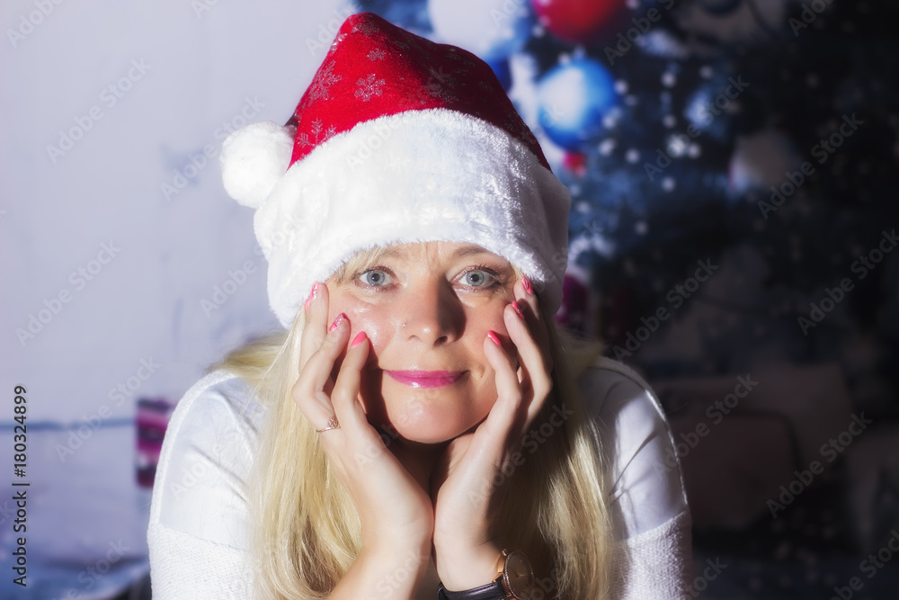 Middle age woman with santa cap on christmas background Middle age woman with santa cap on christmas background