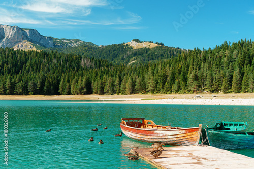 Stunning romantic place with typical wooden boats on the lake pier. Black Lake, Durmitor, Montenegro.