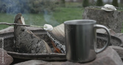 Wallpaper Mural marshmallow is being fried by bonfire in focus, blured hot beverage steaming in the metal cup out of focus Torontodigital.ca