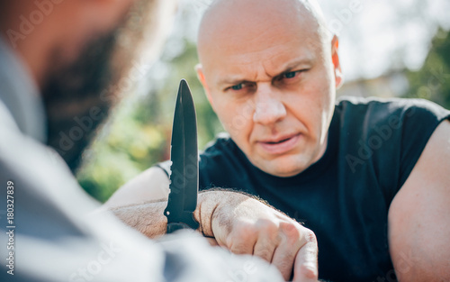 Kapap instructor demonstrates martial arts self defense knife attack disarming
